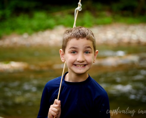 boy smiling with creek in background