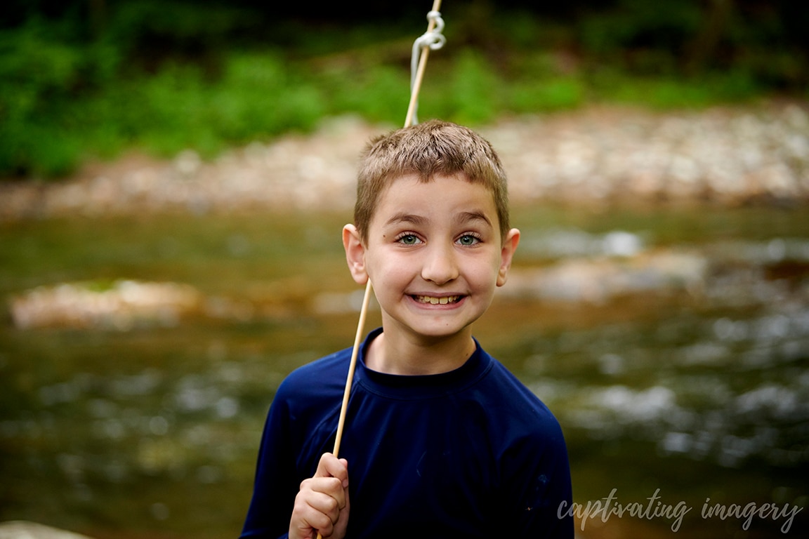 boy smiling with creek in background