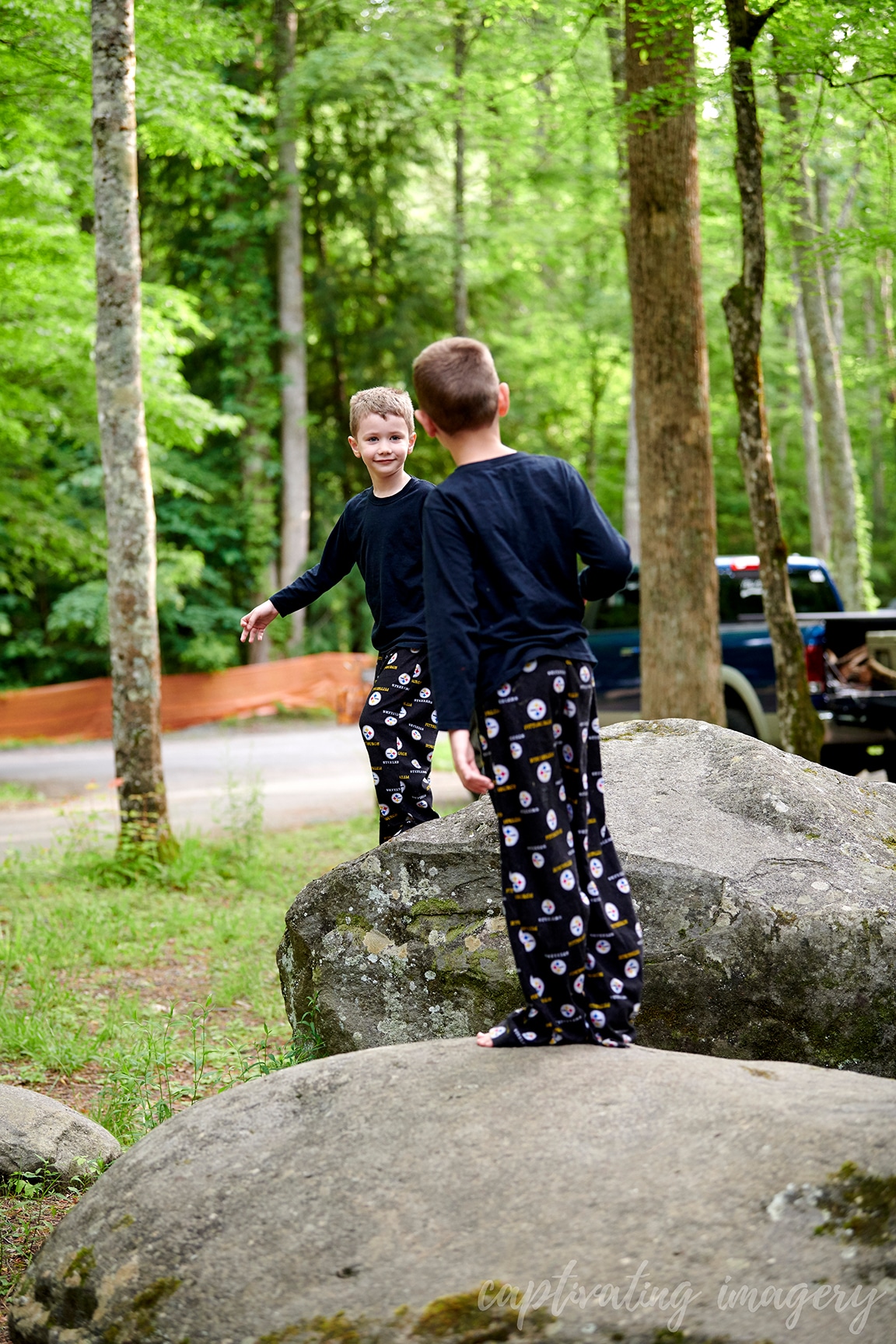 boys play on boulders