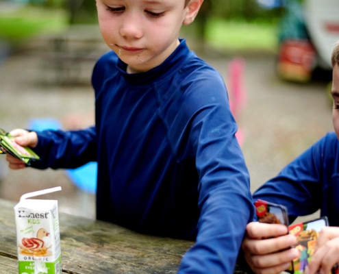 boys play cards at campsite