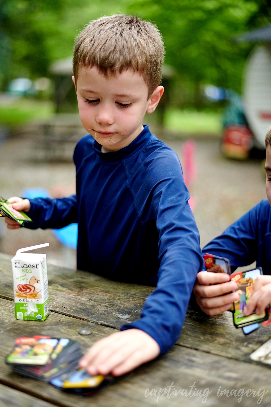 boys play cards at campsite