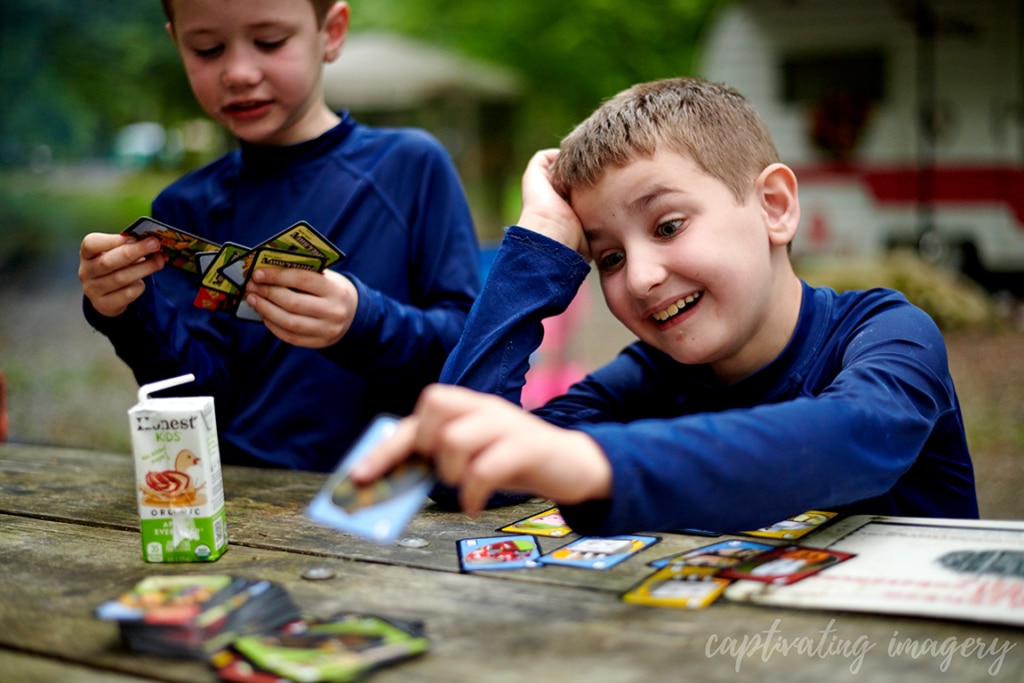 boys play cards at campsite