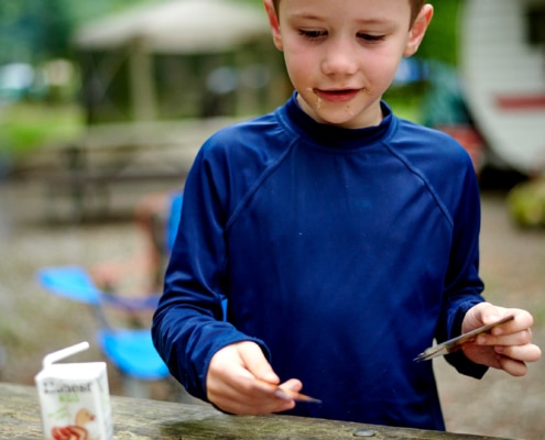 boys play cards at campsite