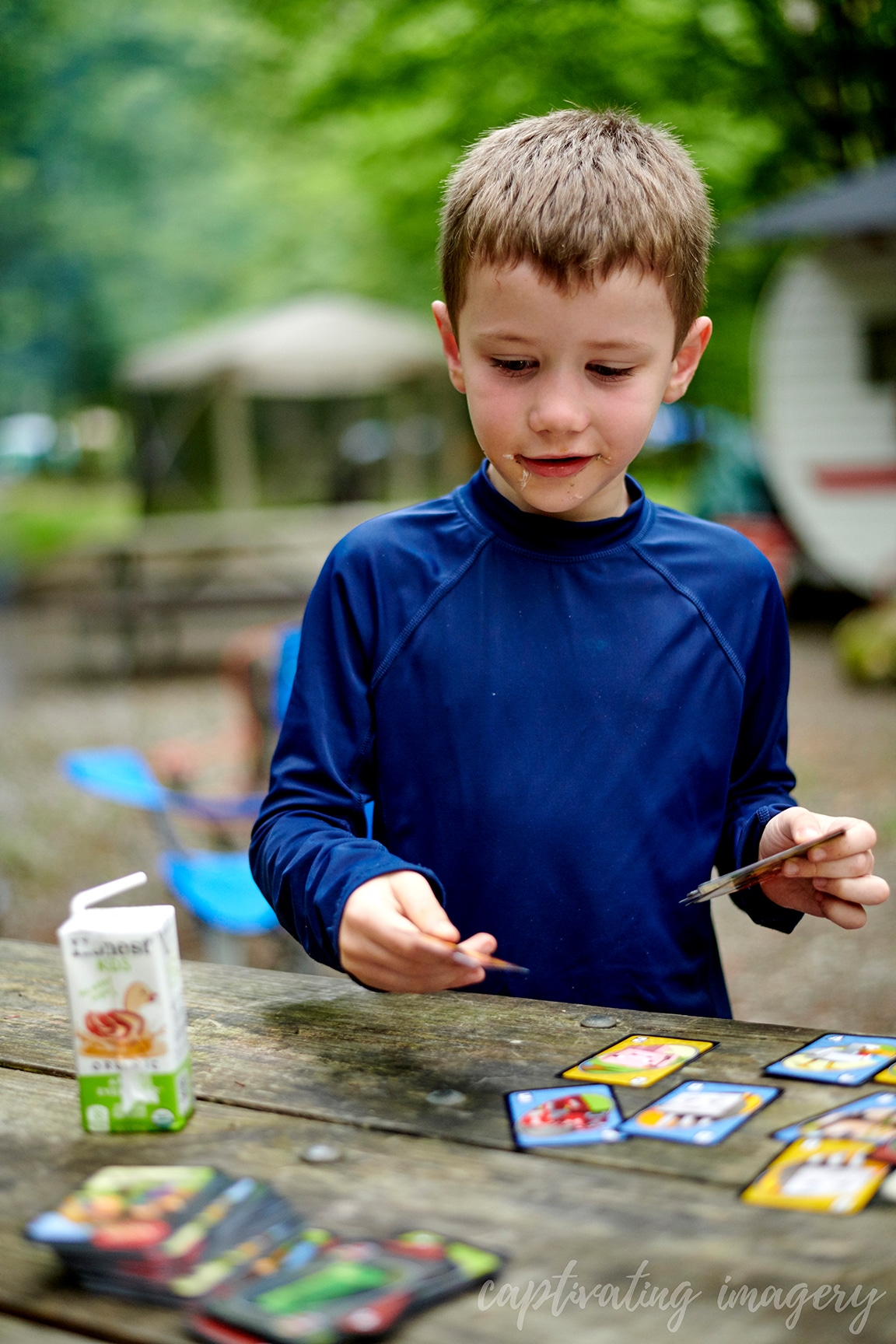 boys play cards at campsite