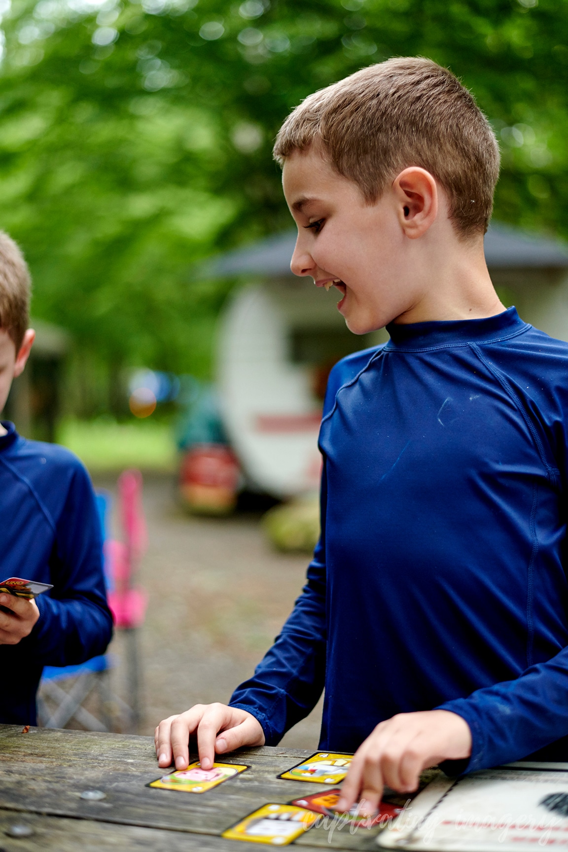 boys play cards at campsite