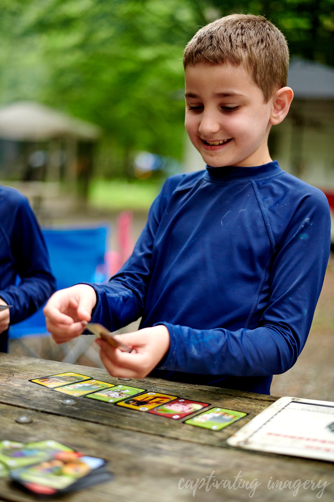 boys play cards at campsite