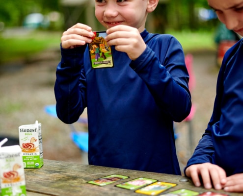 boys play cards at campsite