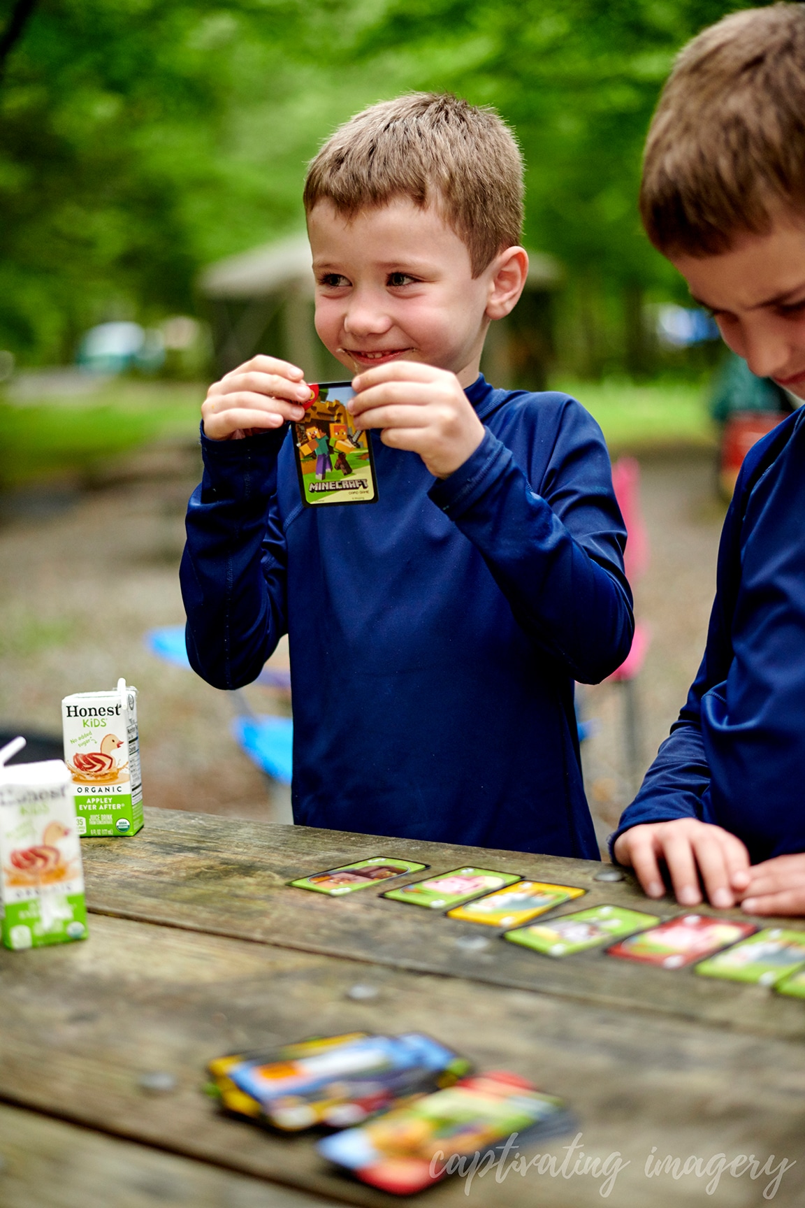 boys play cards at campsite