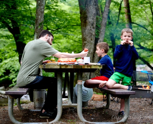 boys and dad eating hot dogs