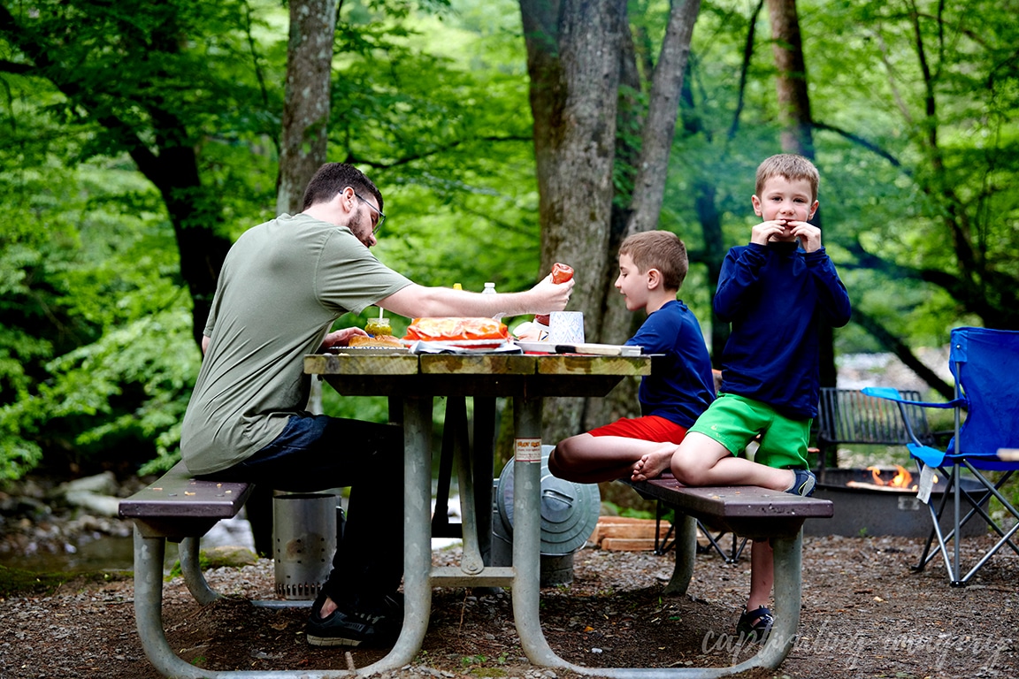 boys and dad eating hot dogs