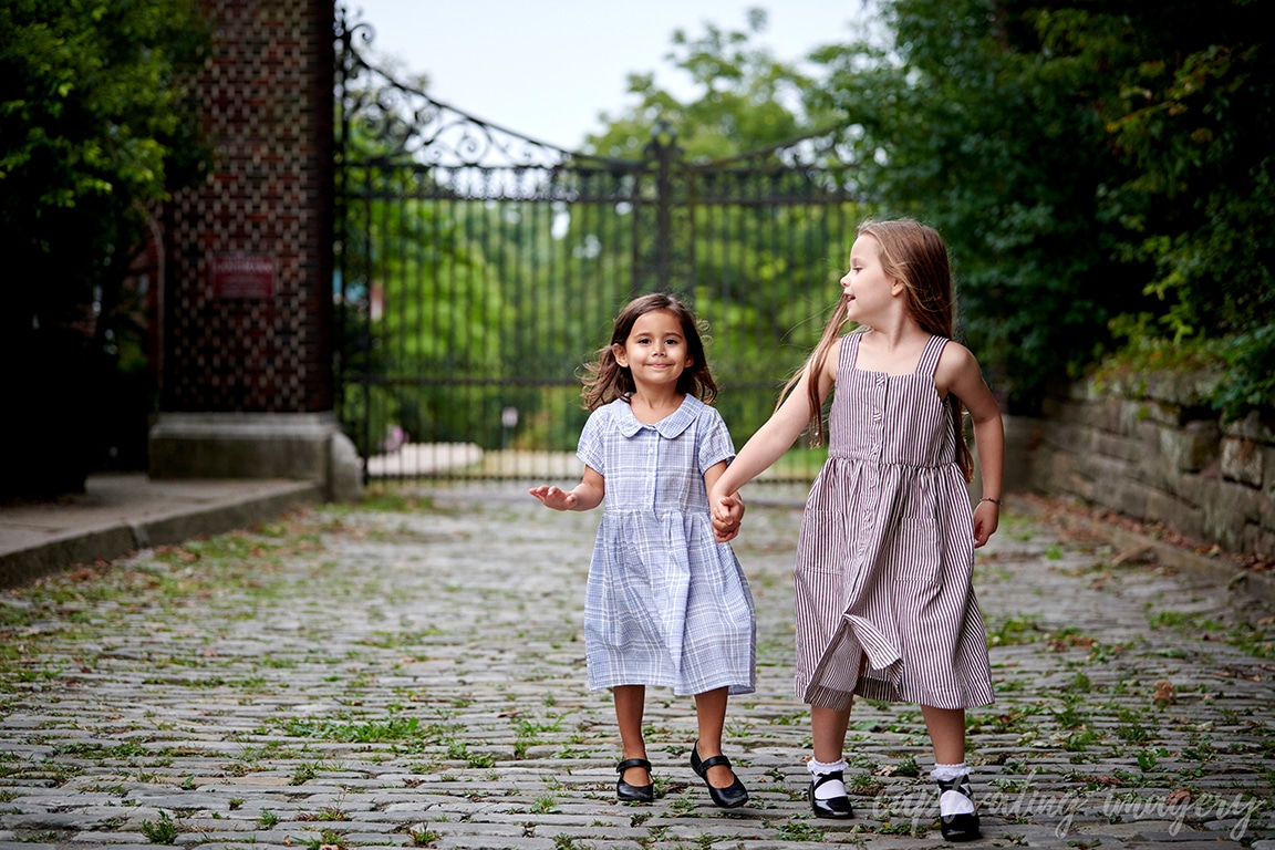 Girls running on cobblestone pathway