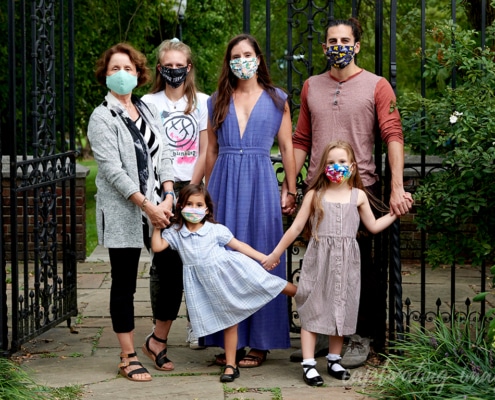 Family wearing masks stands together