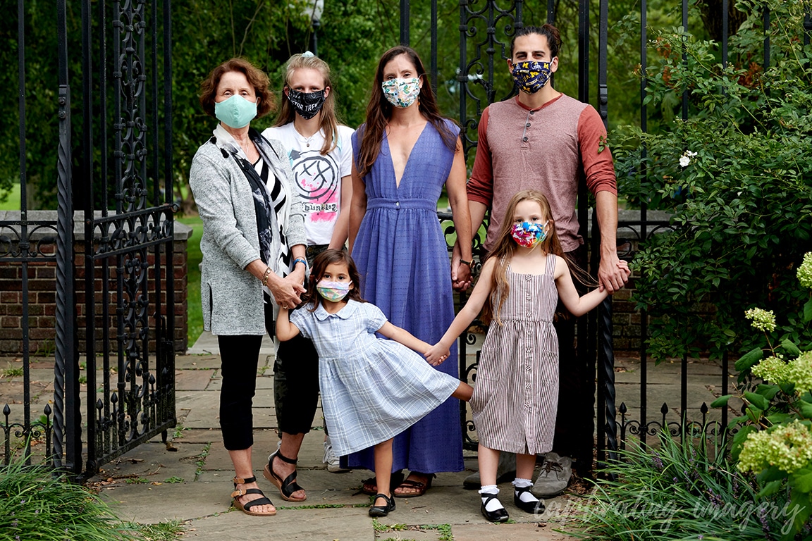 Family wearing masks stands together